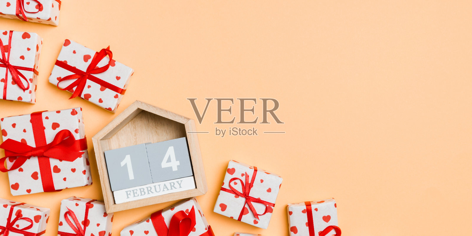 顶视图的礼盒与红色的心和木制日历上的彩色背景。二月十四日。情人节概念与拷贝空间照片摄影图片