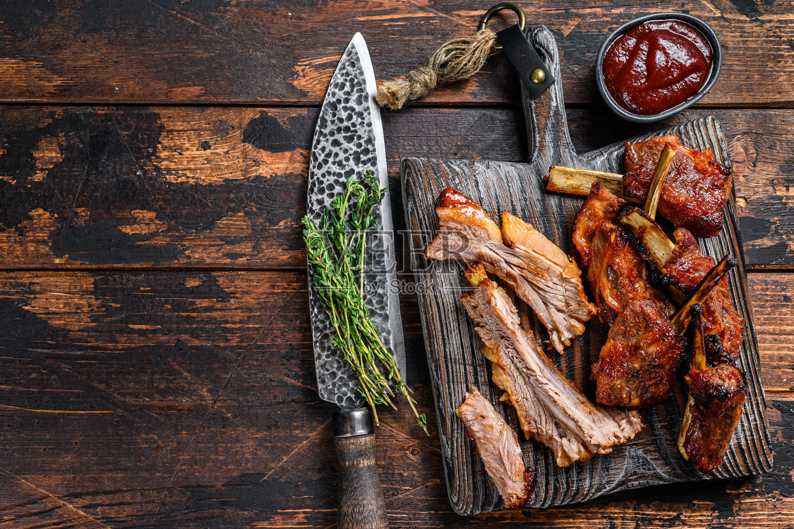 把烤好的小牛肉排放在砧板上烤。深色木制背景。前视图。本空间照片摄影图片