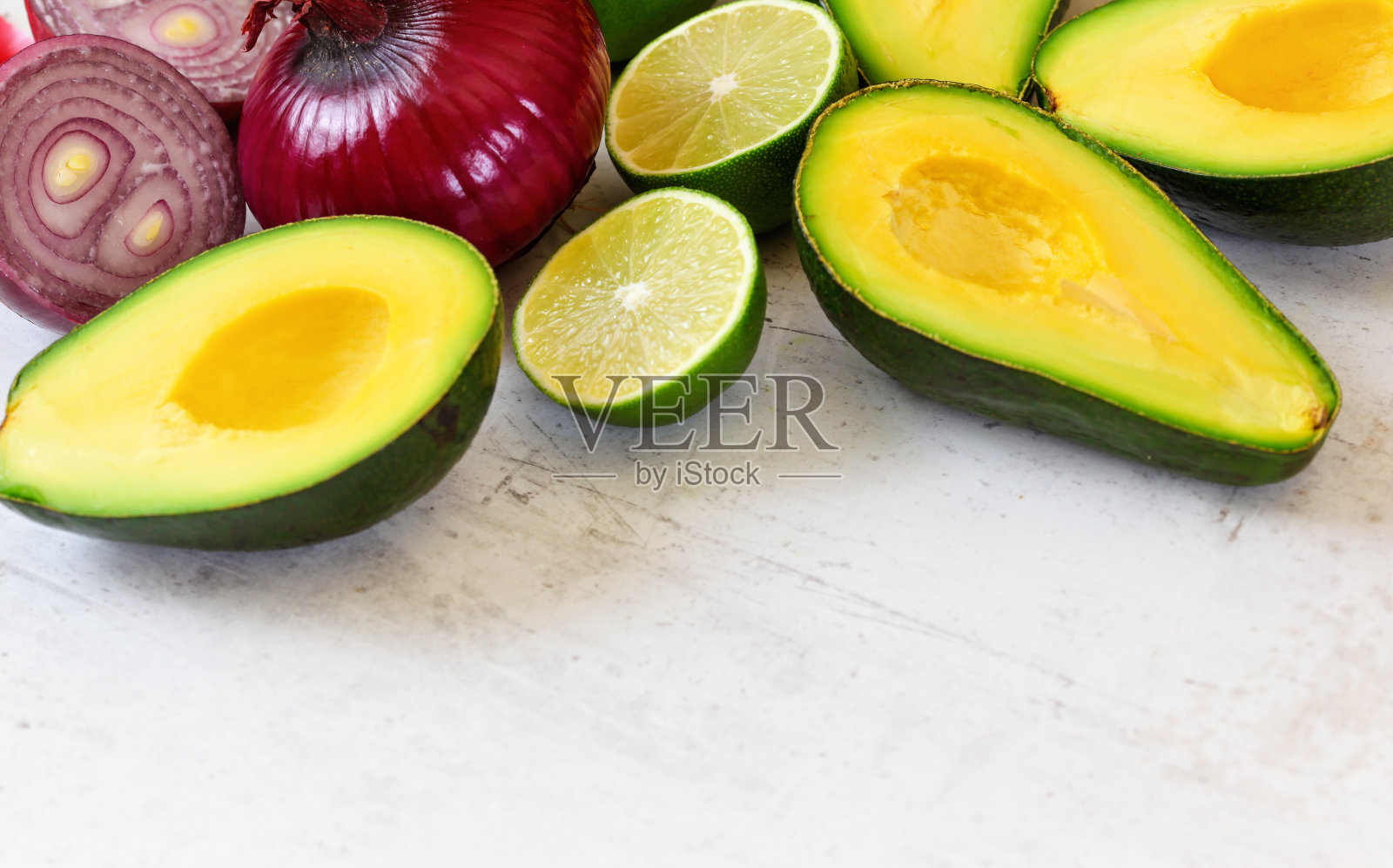 牛油果，酸橙和洋葱-基本的牛油果酱配料在白色工作板上，下面有文字照片摄影图片