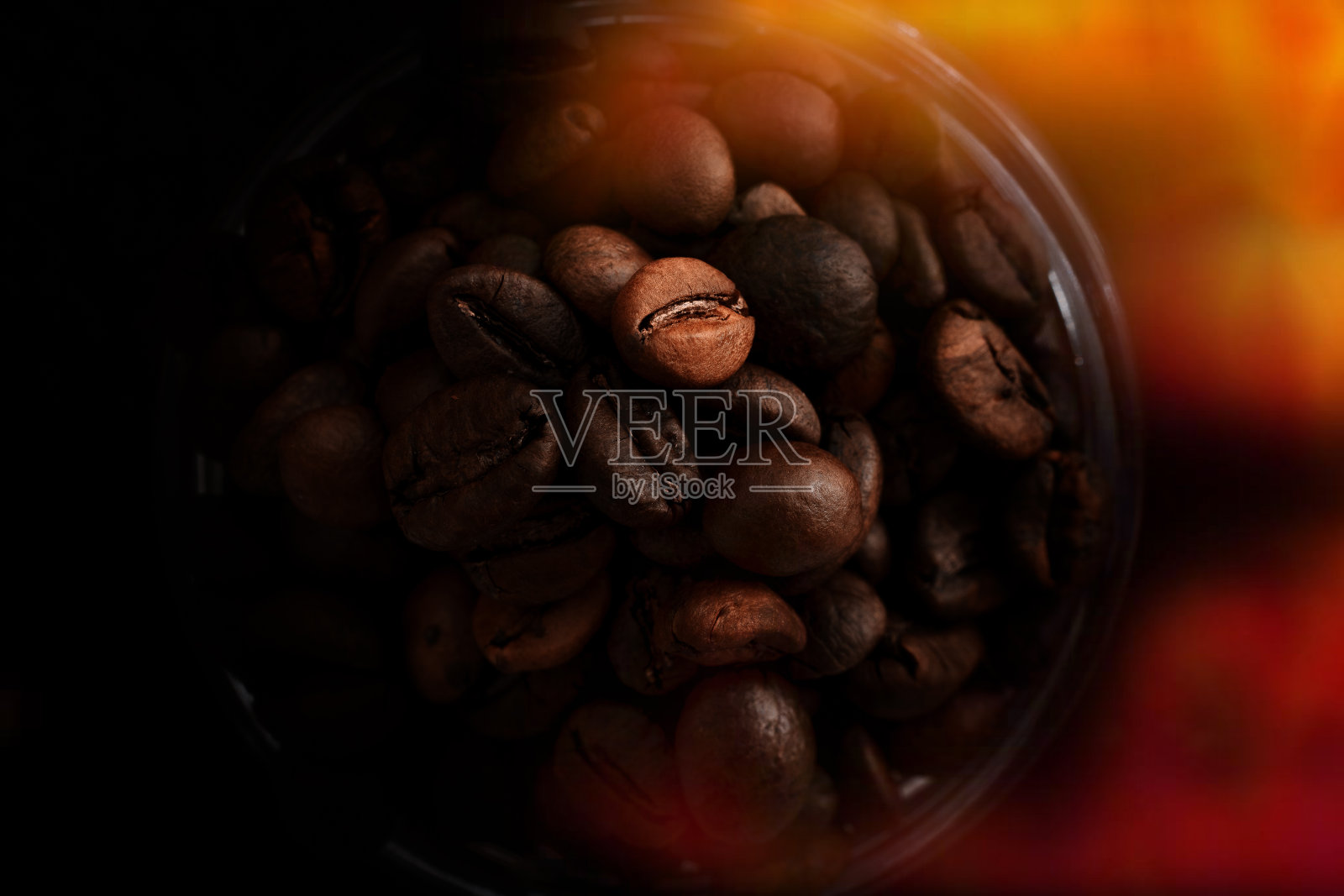 新鲜烘焙的咖啡豆在一个玻璃容器俯视图，在一个黑暗的钥匙照片摄影图片