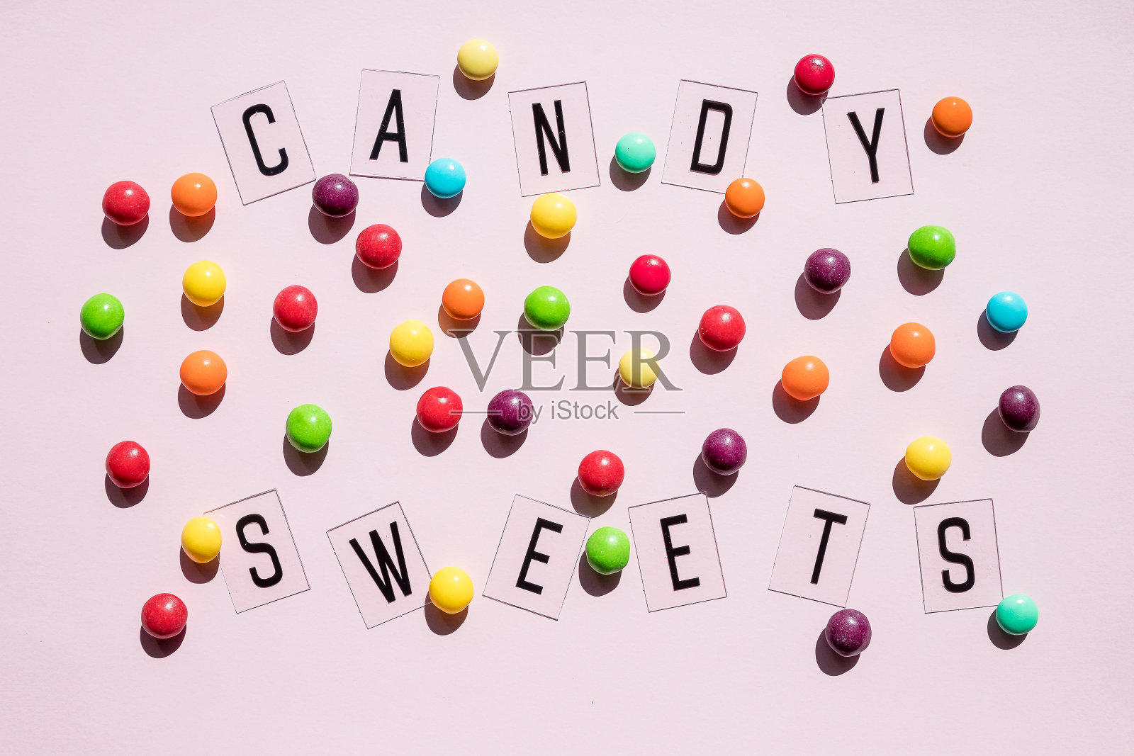 生日的概念。节日食物俯视图各种糖果在粉红色的背景。有趣的装饰。最小的节日的概念。图案棒棒糖，糖果，橘子酱，食物背景照片摄影图片