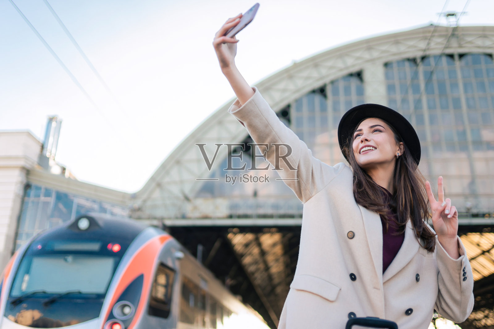 一名女游客兴高采烈地站在火车站的月台上自拍照片摄影图片