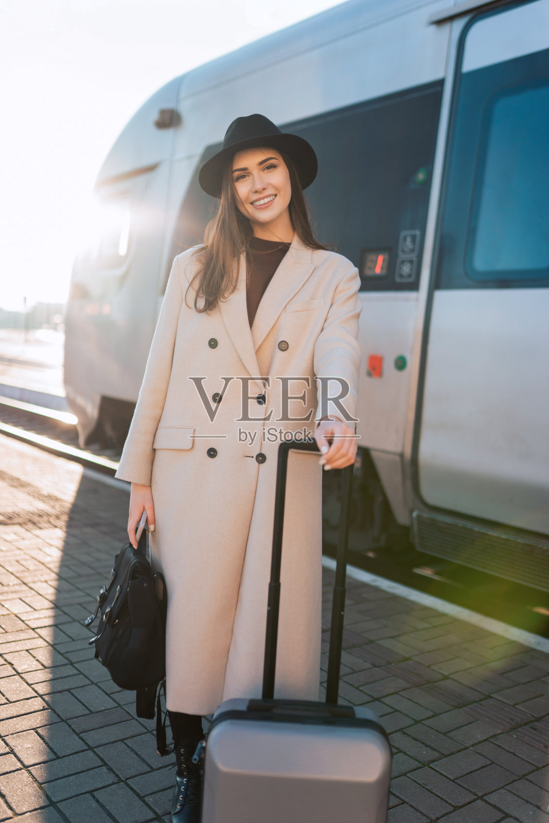 美丽的女商人拿着行李在火车站的月台上照片摄影图片