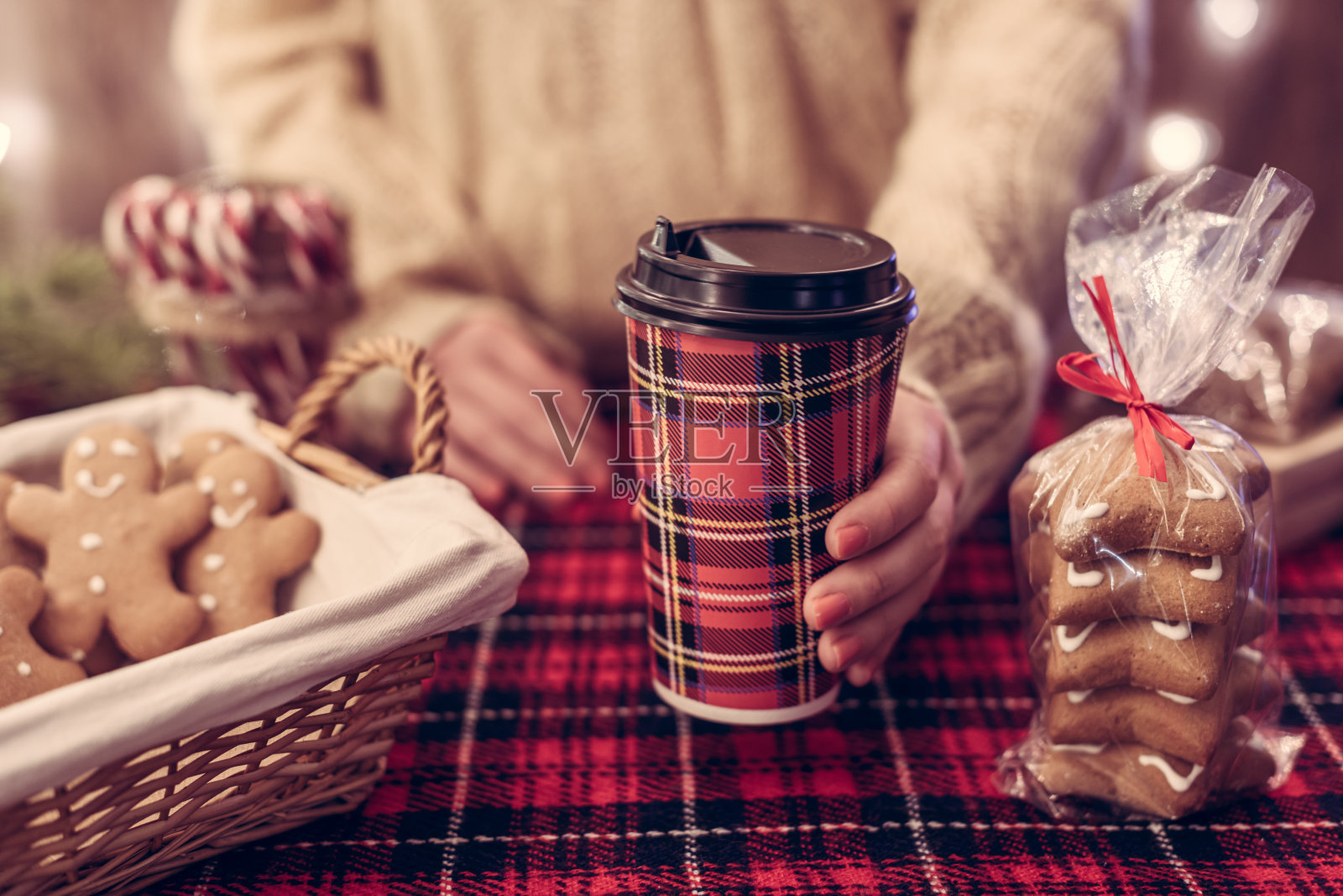 圣诞糕点店。女人提供热巧克力，拿铁在纸杯，姜饼饼干，糖果在一个小舒适的咖啡馆。照片摄影图片