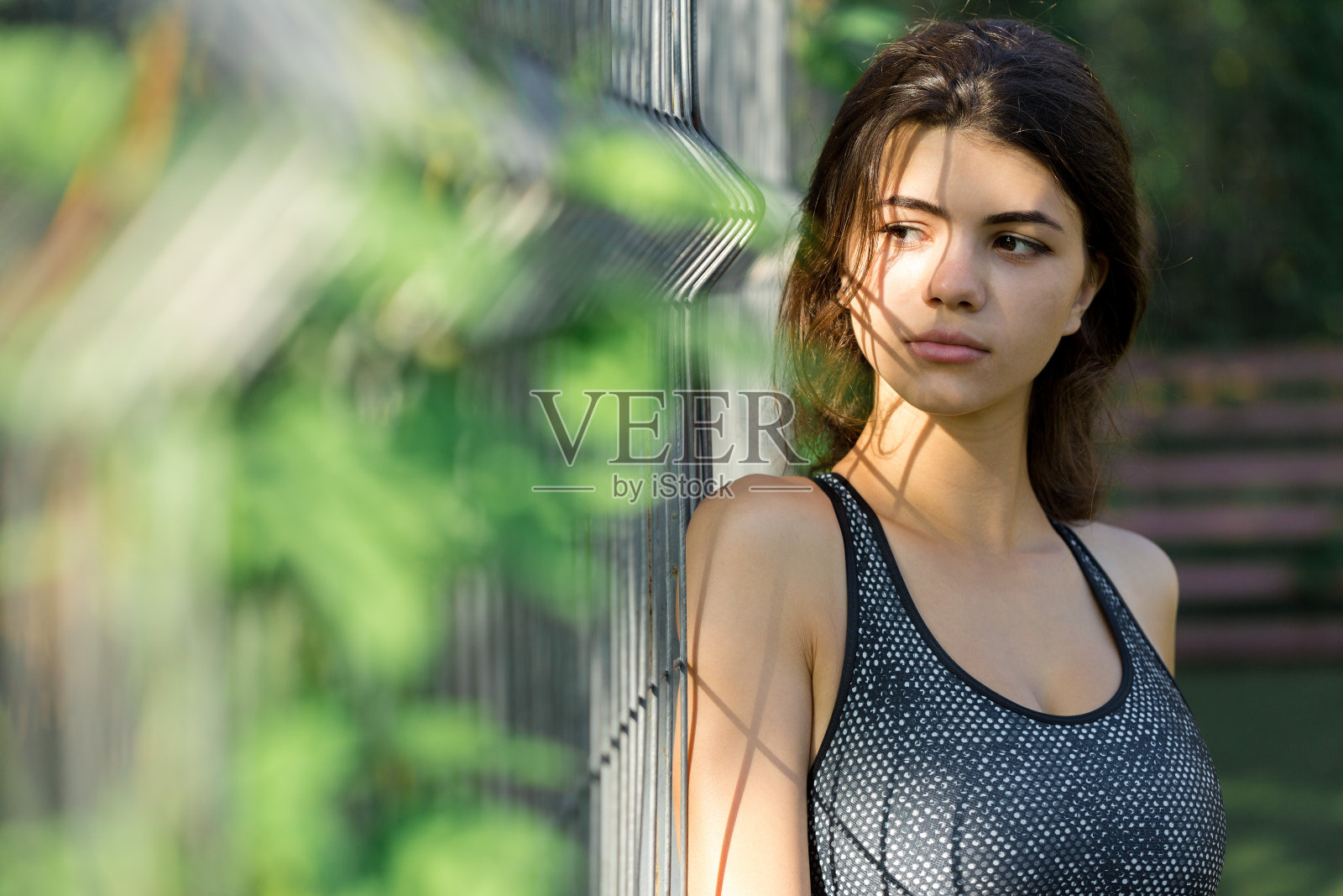 一个年轻苗条的运动女孩穿着印有蛇皮图案的运动服进行一套练习。健康的生活方式。照片摄影图片