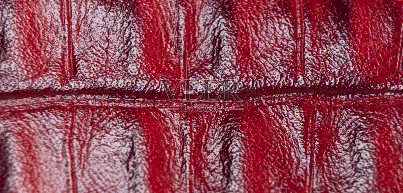 红色穿孔皮革纹理背景。红色皮革特写。微距镜头闪光的皮革纹理。照片摄影图片