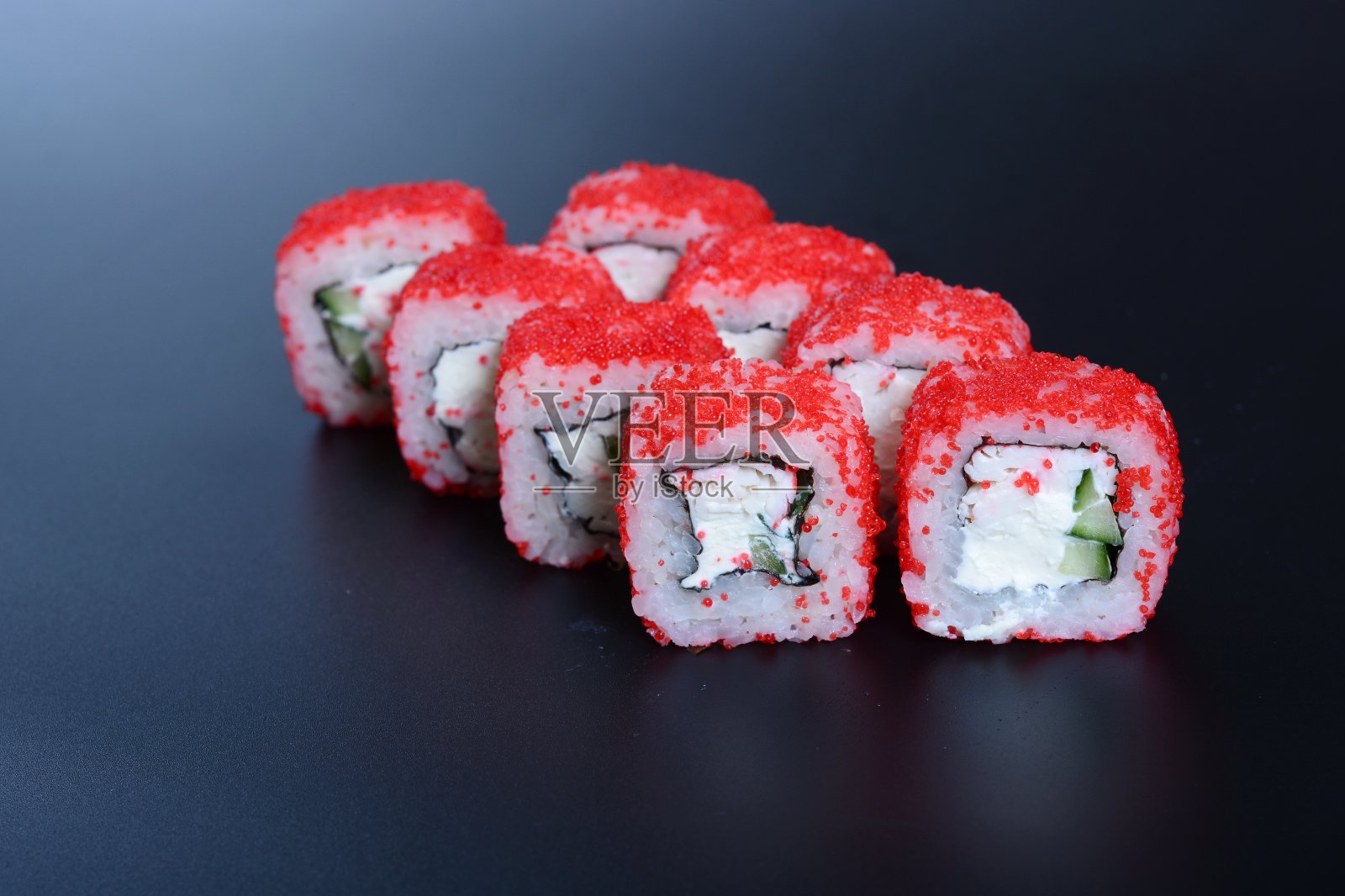 深色的石头背景上是五颜六色的海鲜卷和米饭照片摄影图片