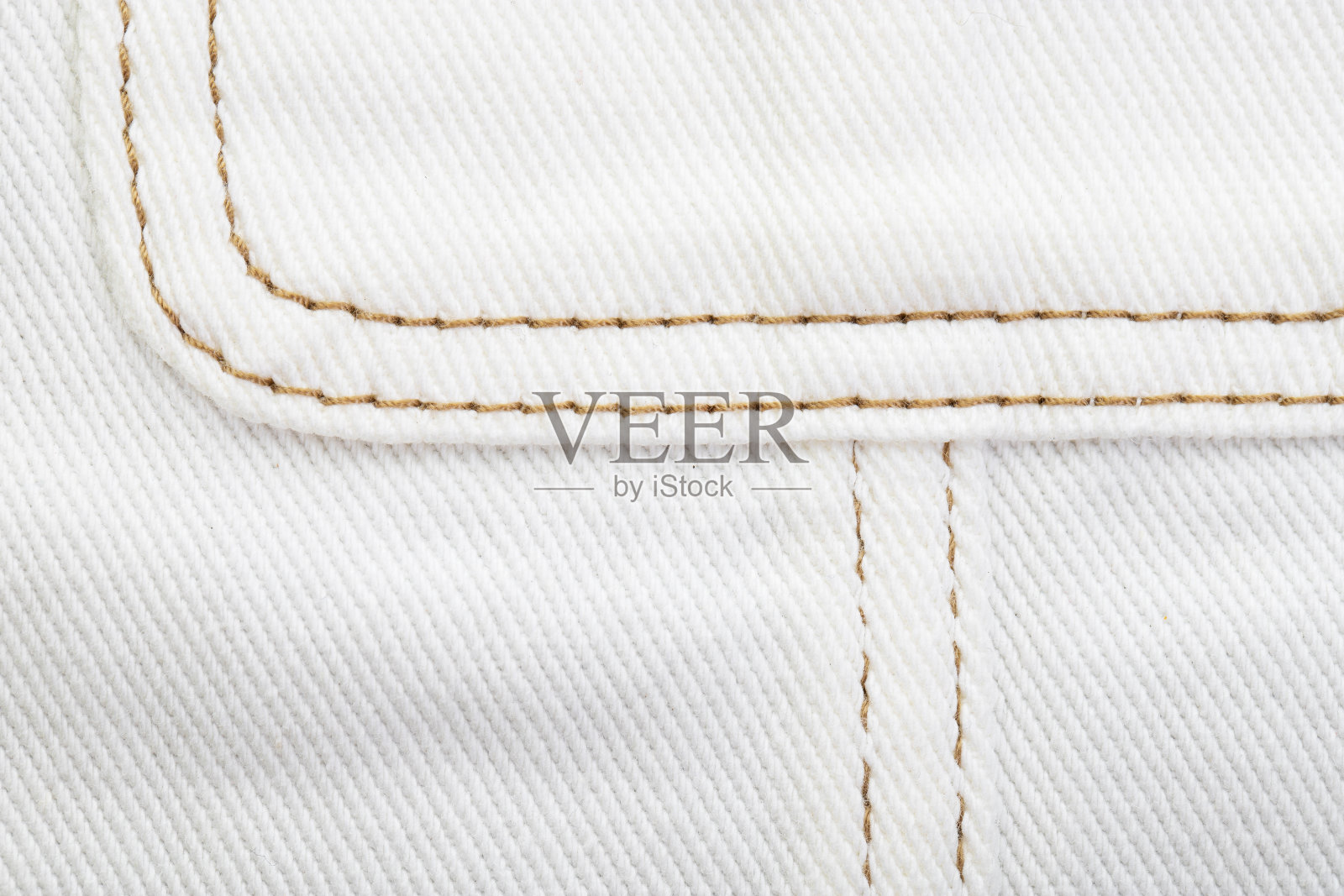 牛仔布，用棕色线连接各种接缝，毛边和流苏照片摄影图片