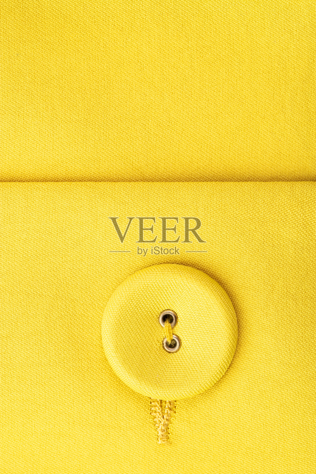 开槽环上的一种扣件，由机器缝加工而成，钮扣以黄色为主布覆盖照片摄影图片
