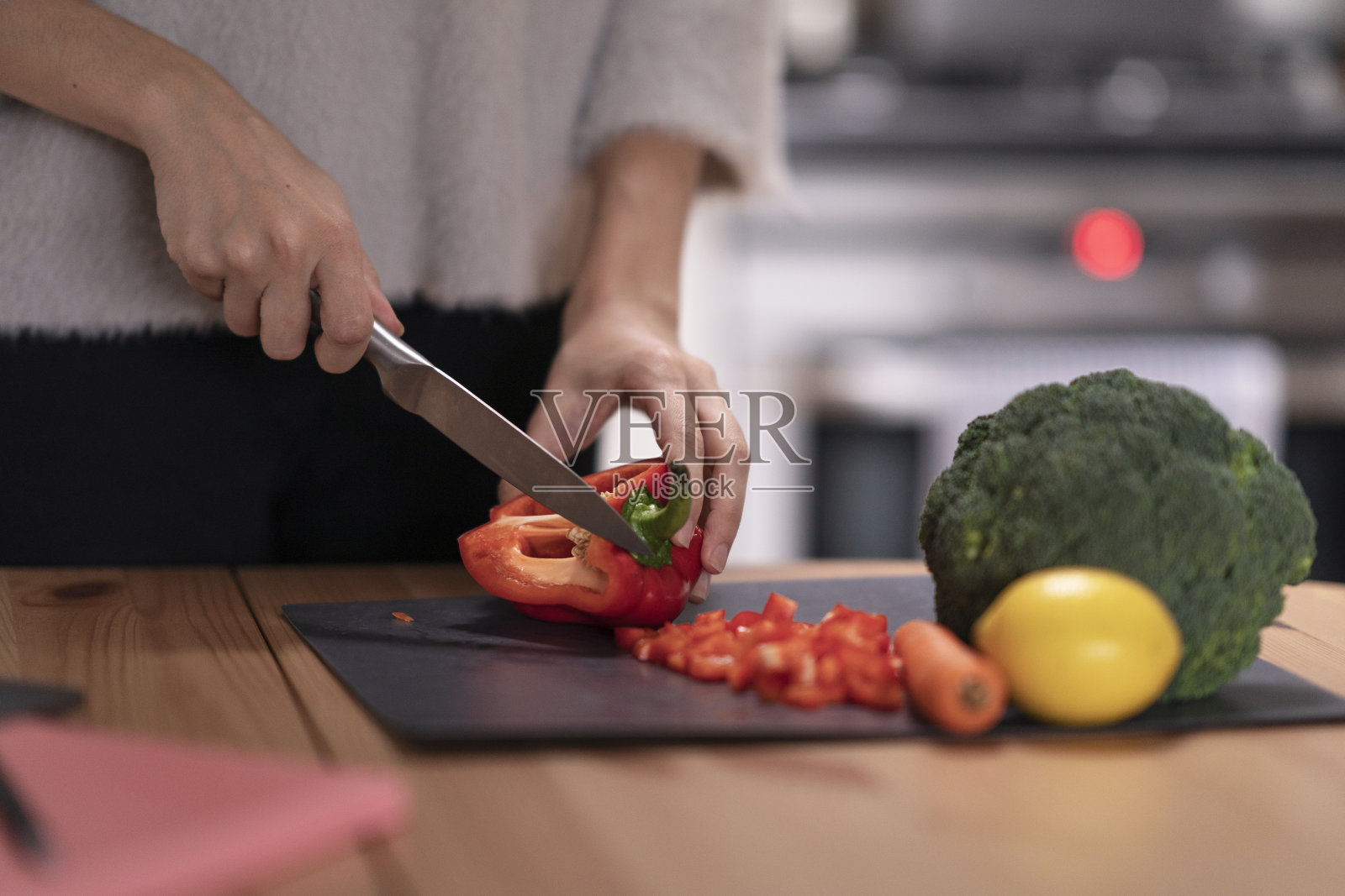 在厨房切蔬菜的女人。手切有机食品的特写照片摄影图片
