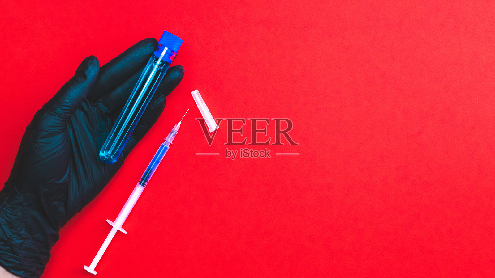 注入。医生手持医用手套，手持注射器和针头，以保护流感病毒和冠状病毒。冠状病毒疫苗在红色上分离。护士或医生。液体药物或麻醉剂。照片摄影图片