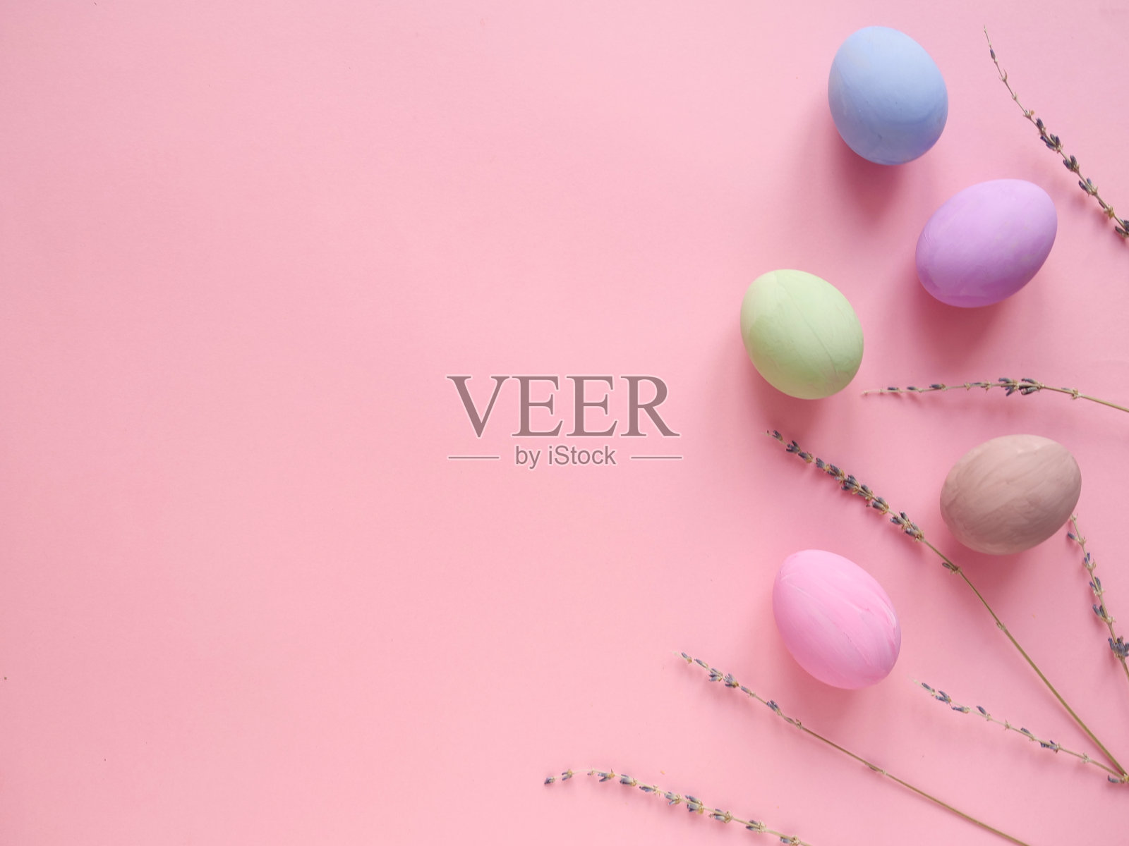 平铺构图复活节快乐节日的概念。粉彩蛋与薰衣草在粉红色的背景。Copyspace,俯视图照片摄影图片