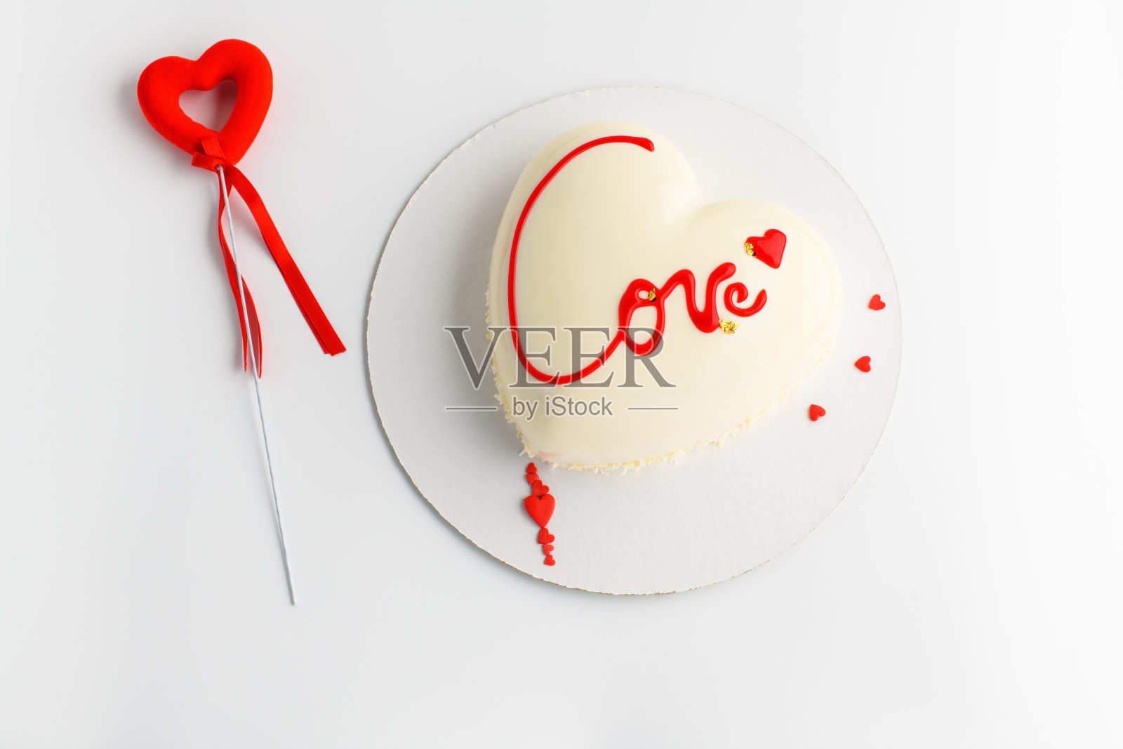 心形的蛋糕。慕斯轻蛋糕形状的心与铭文与红色的心在灰色的背景。情人节。照片摄影图片