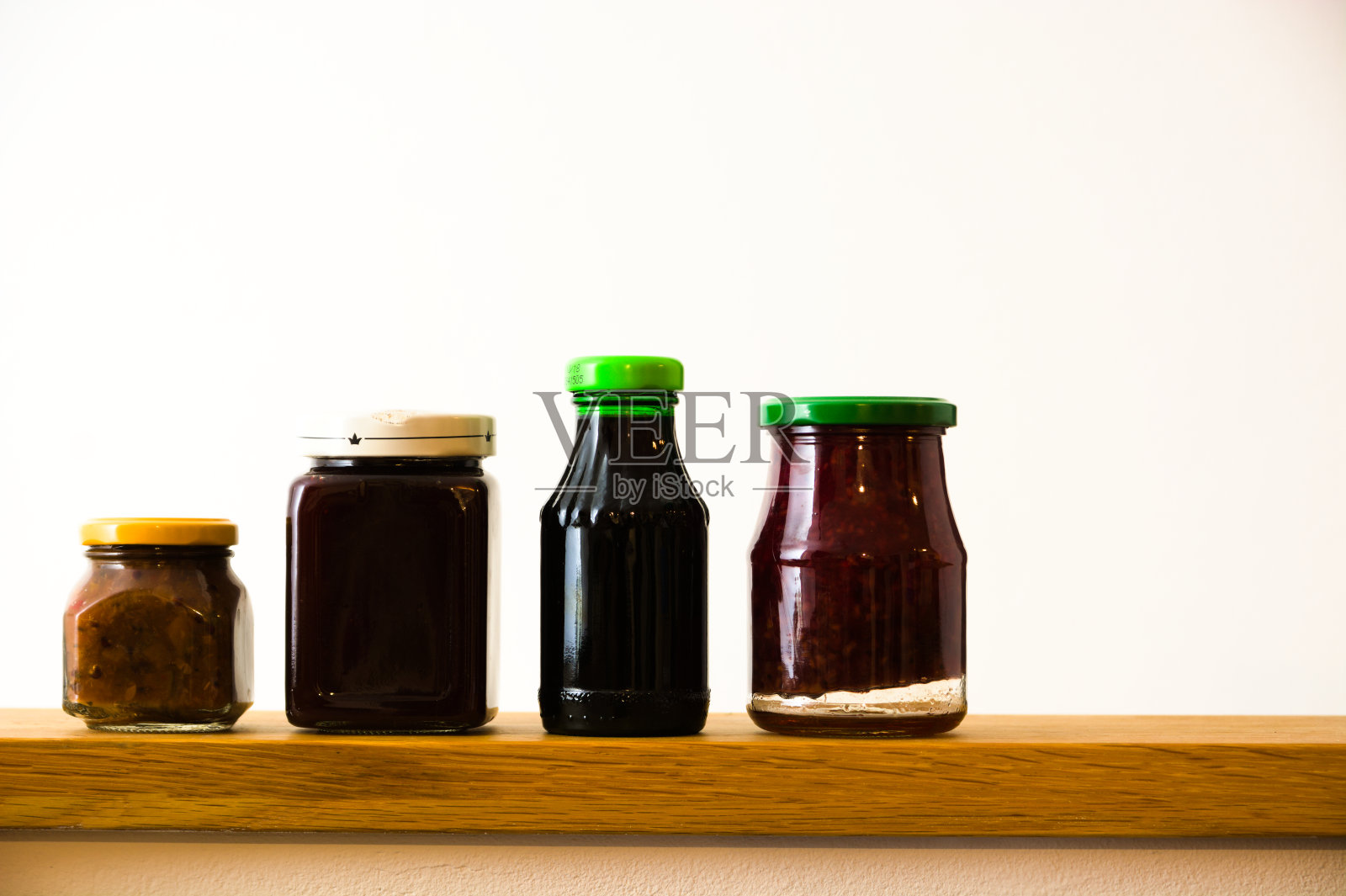 木桌上放着装着各种果酱的玻璃瓶照片摄影图片