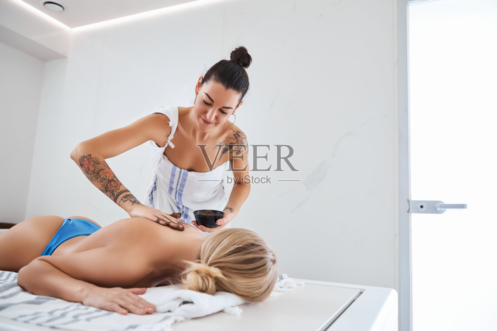 美丽优雅的女性在水疗过程中放松下来的桌子照片摄影图片