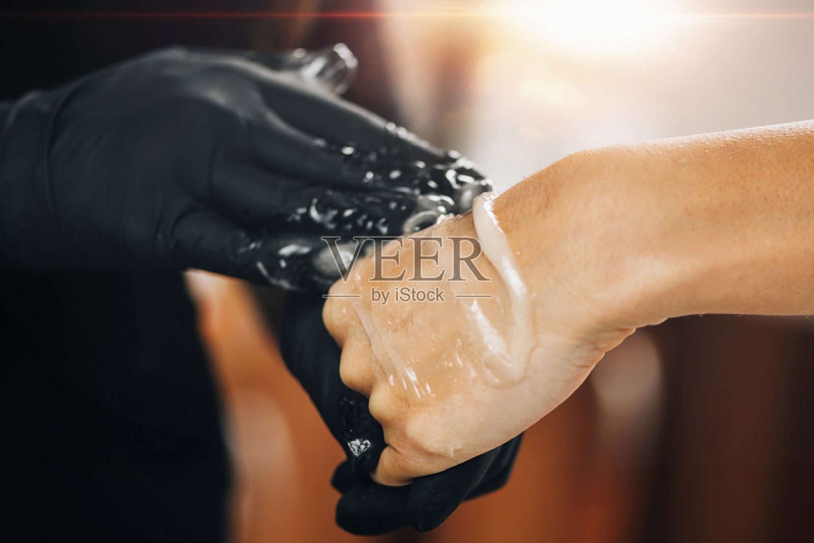 糖脱毛，美容师在女性手上涂抹糖膏照片摄影图片