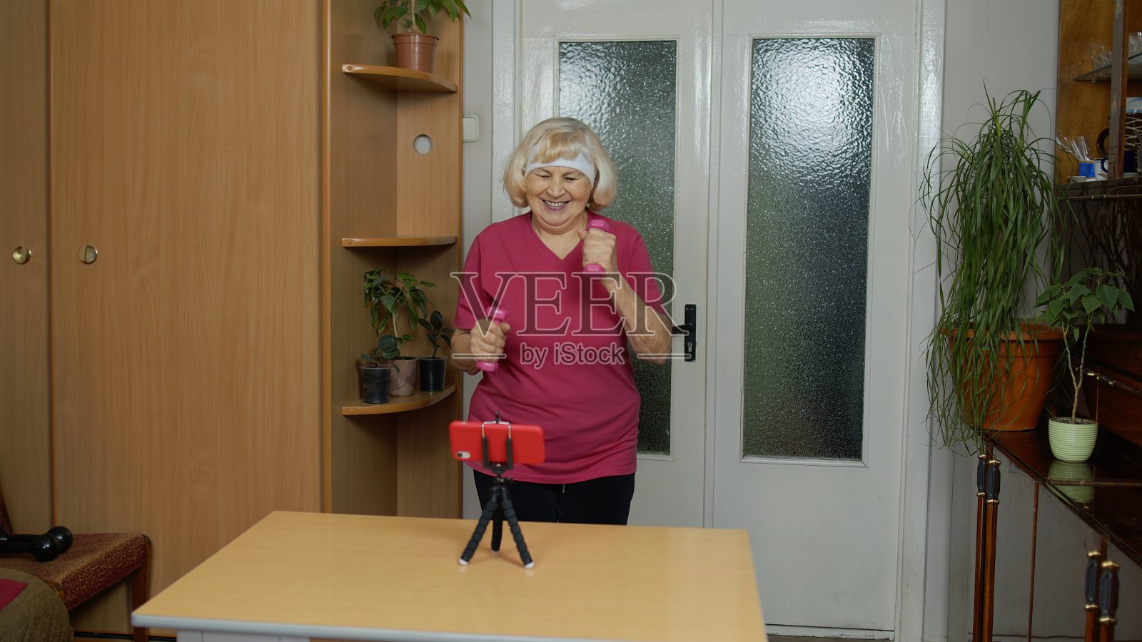 成熟的夫妇男子健身教练教练记录视频在线健身博客课程与智能手机照片摄影图片