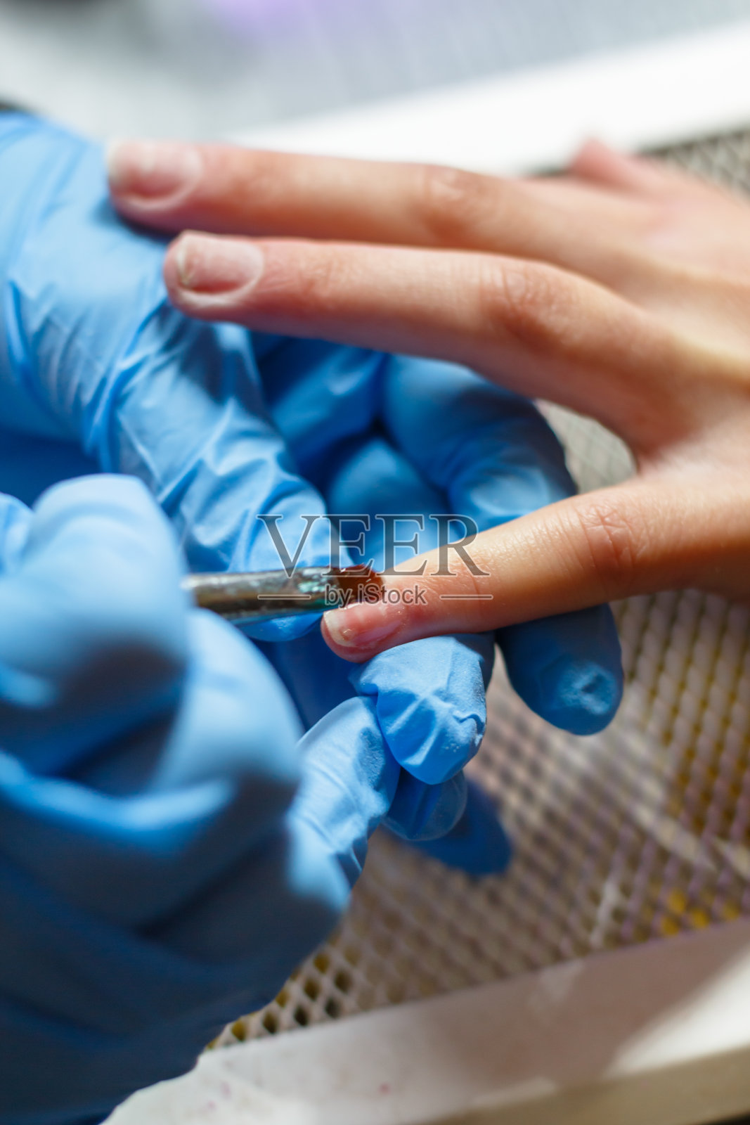年轻女子在做指甲后，panaritium治疗照片摄影图片