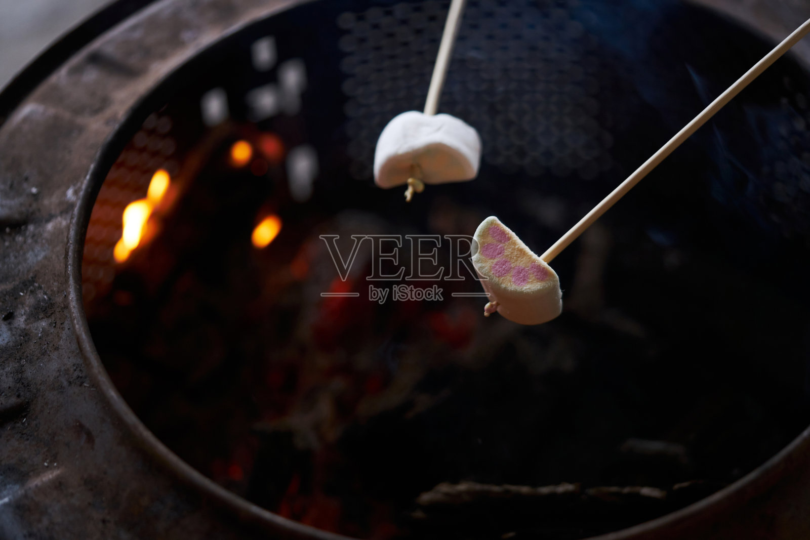 棉花糖棒挤在烧烤火上照片摄影图片