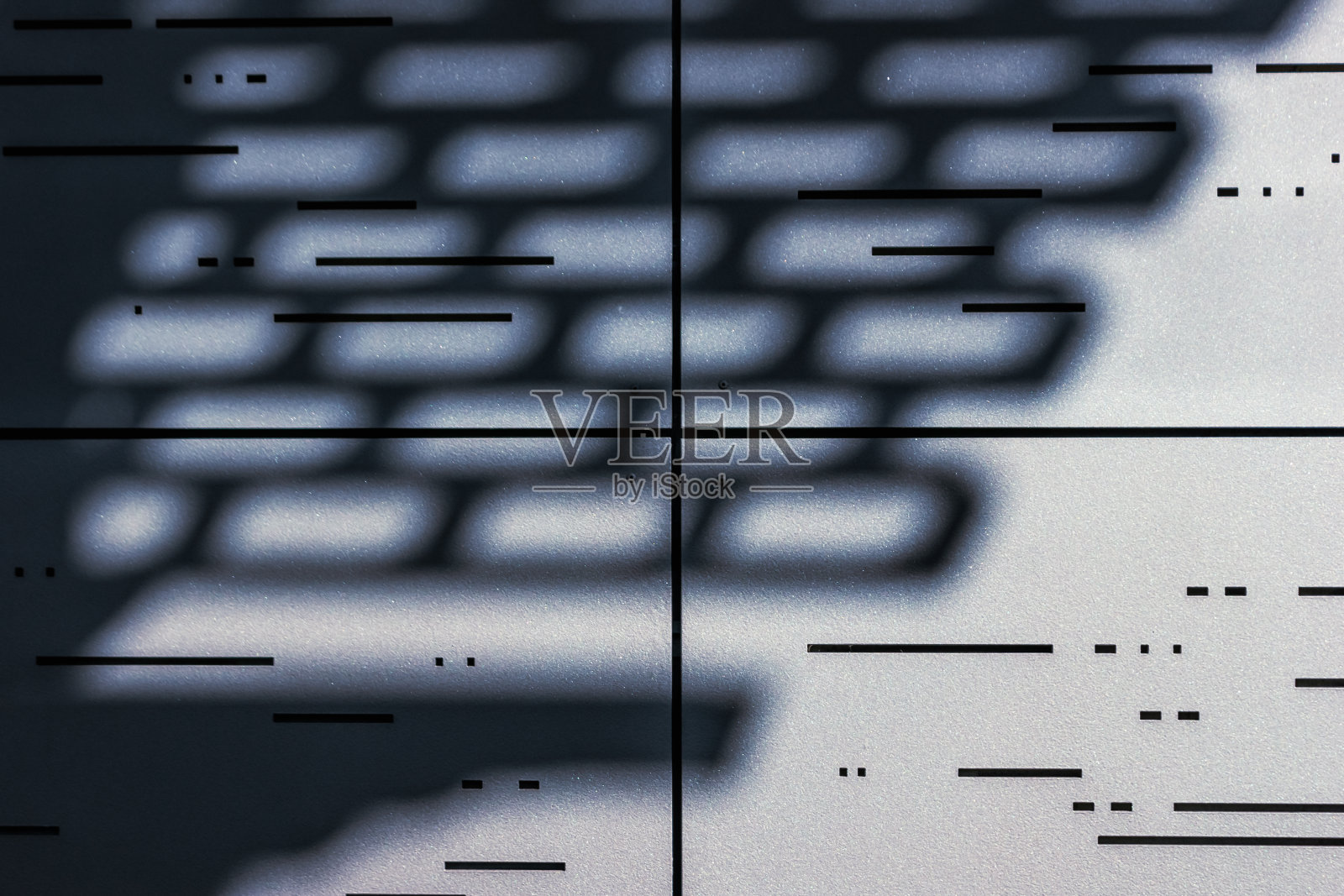 金属顶棚的阴影落在现代的金属镶板墙上照片摄影图片