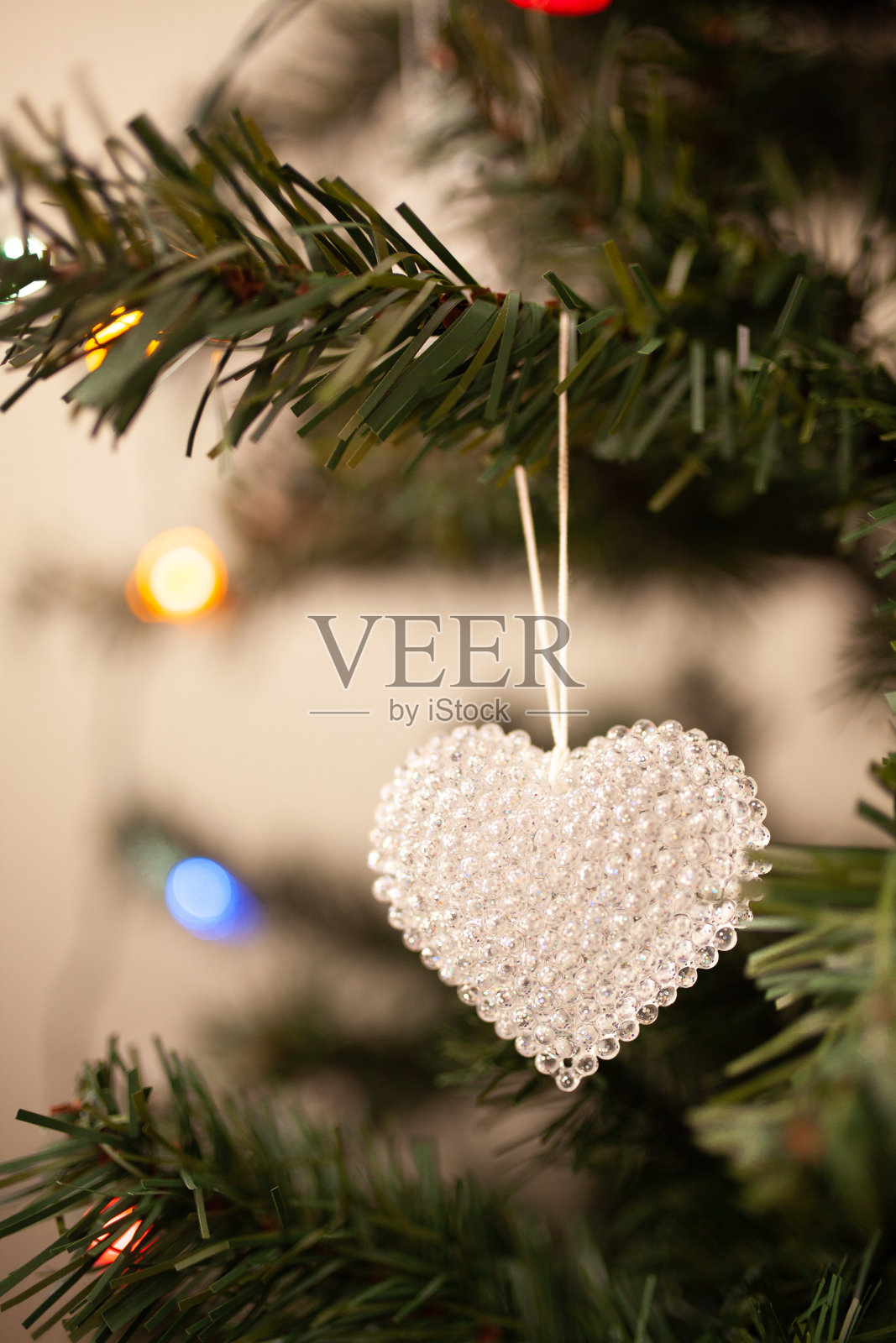 水晶心圣诞树装饰在绿色的树枝上，用串灯和拷贝空间。冬天爱卡,照片摄影图片