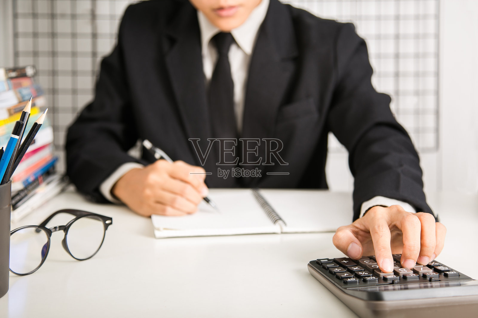 商人手用计算器计算奖金(或其他补偿)给员工以提高生产力。书桌上的信纸。有选择性的重点照片摄影图片