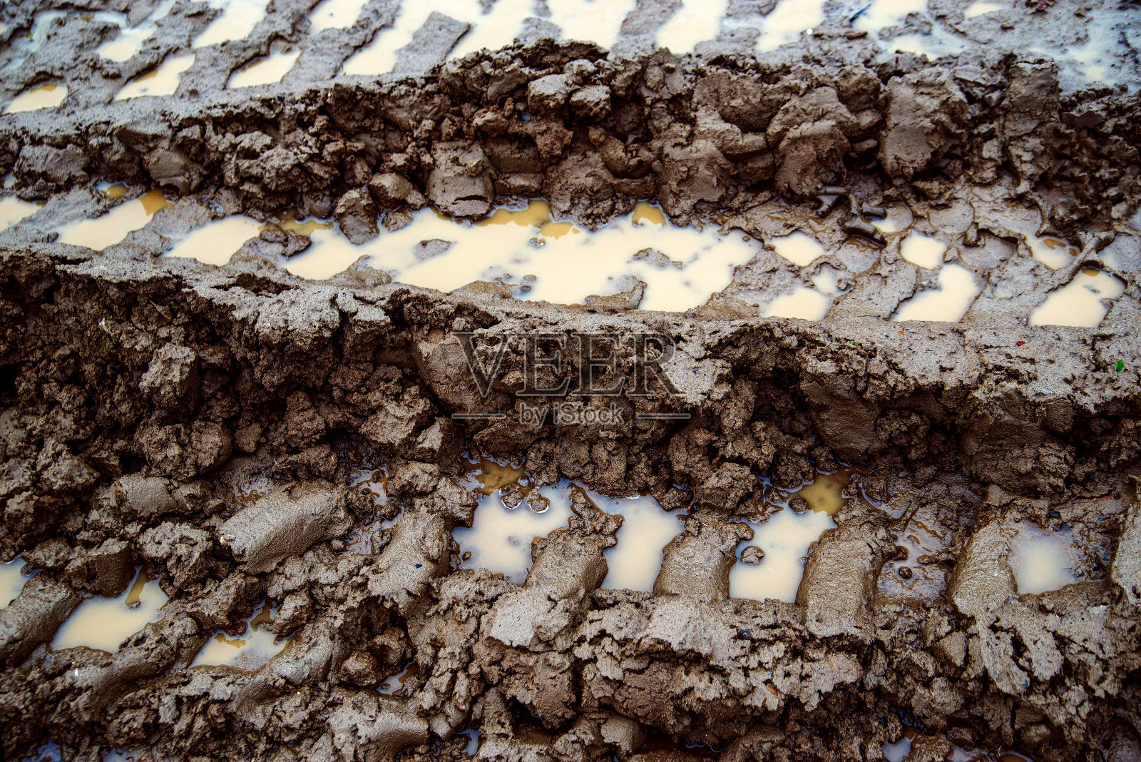 泥上有轮胎印。在无法通行的道路上有水坑和交通痕迹的泥泞照片摄影图片