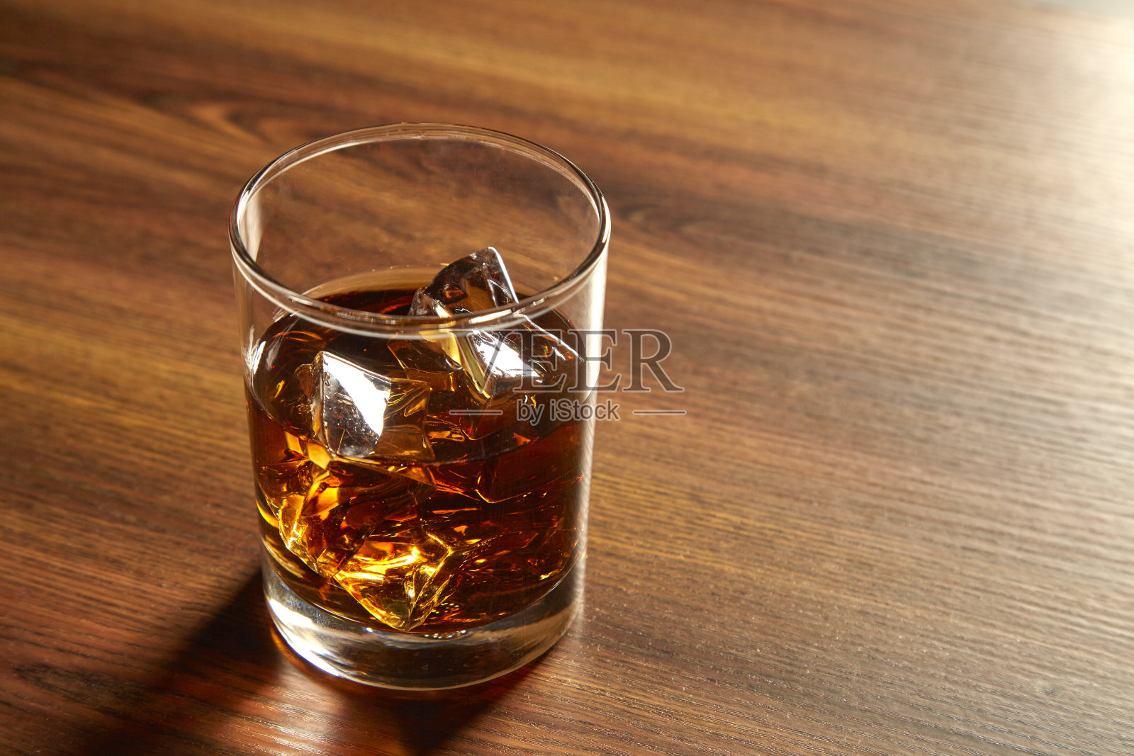 木桌上放着一杯冰威士忌照片摄影图片