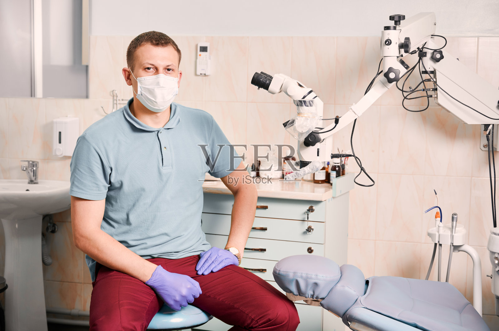 英俊的男牙医竖起大拇指。照片摄影图片