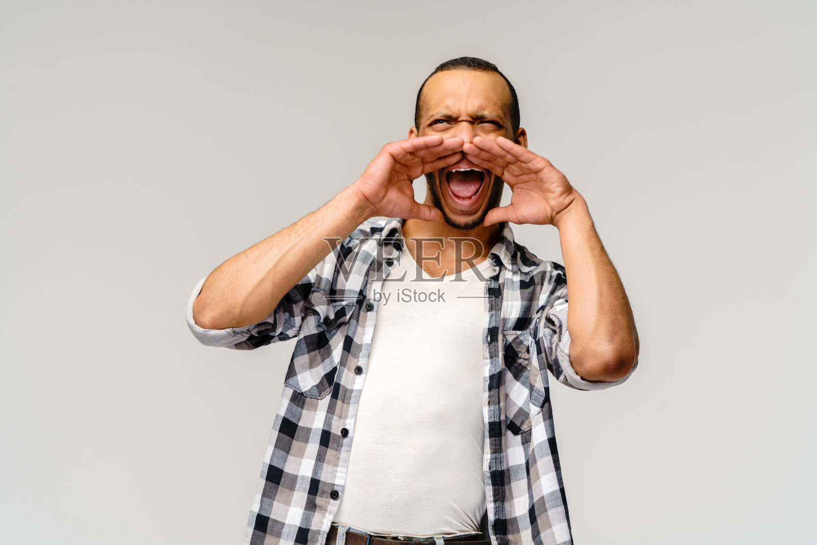 年轻的非洲裔美国人在灰色的背景下喊叫照片摄影图片