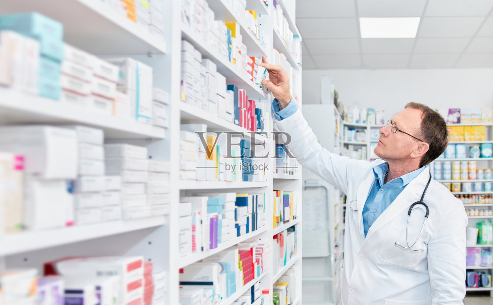 药剂师在药店检查货架上的药品照片摄影图片