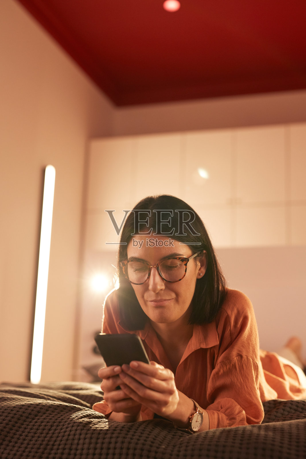 成年女性在床上使用智能手机照片摄影图片