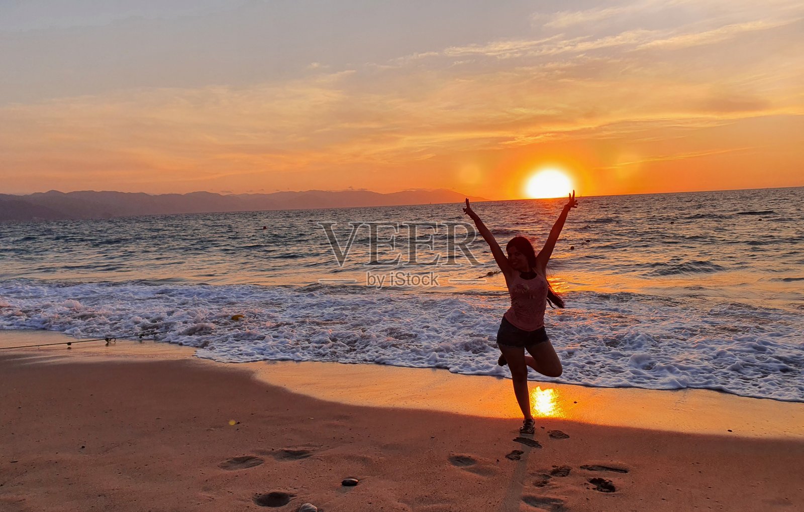 女人在平静的大海前庆祝她的自由照片摄影图片