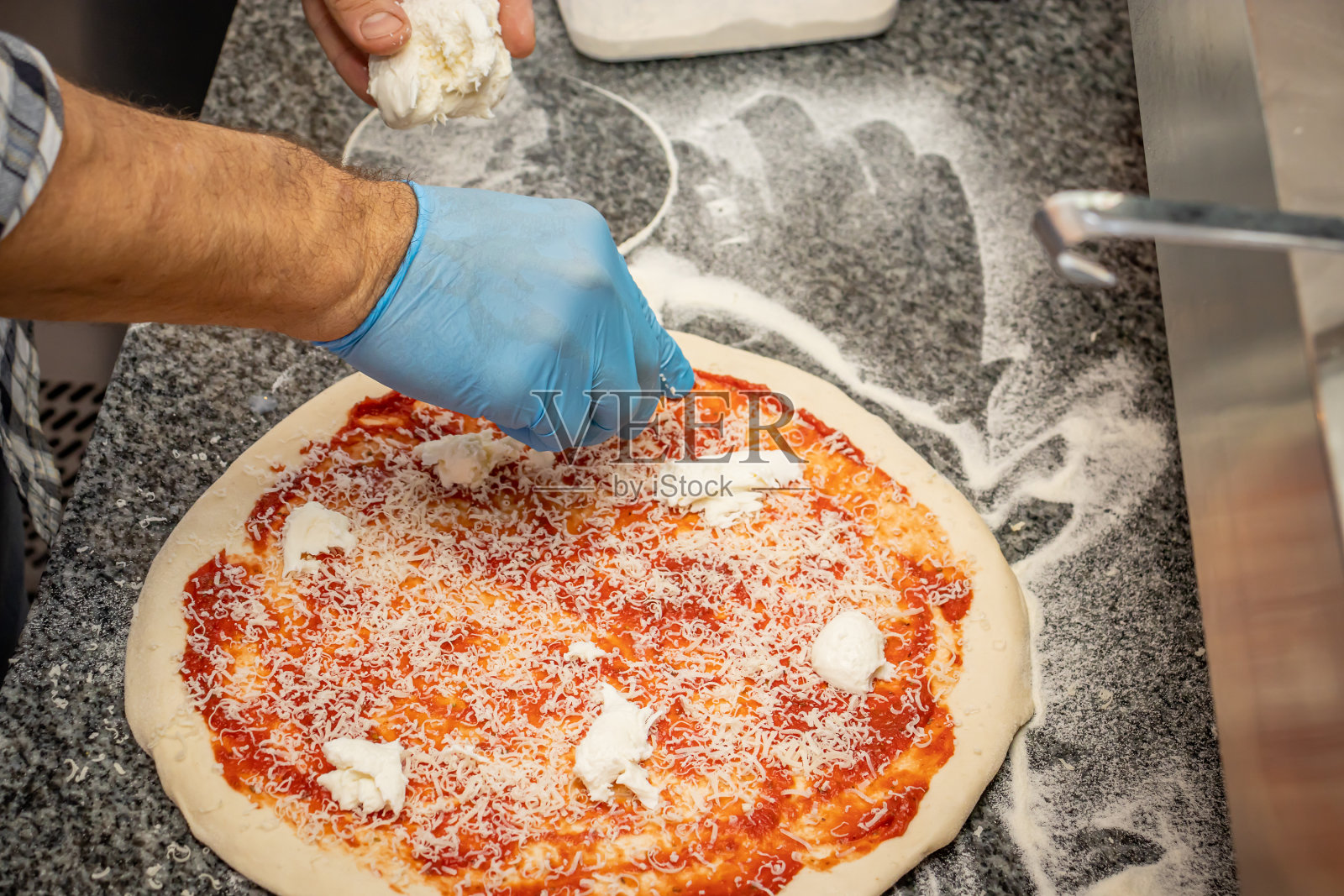 一个男人在当地的披萨餐厅做玛格丽塔披萨照片摄影图片