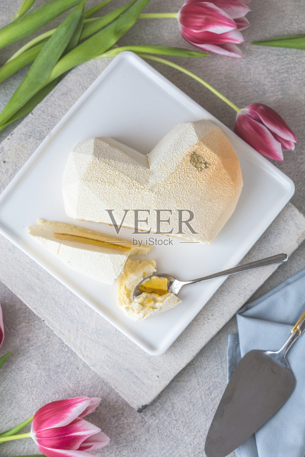 心形的蛋糕。奶油轻蛋糕在一个心形的灰色背景。情人节。照片摄影图片