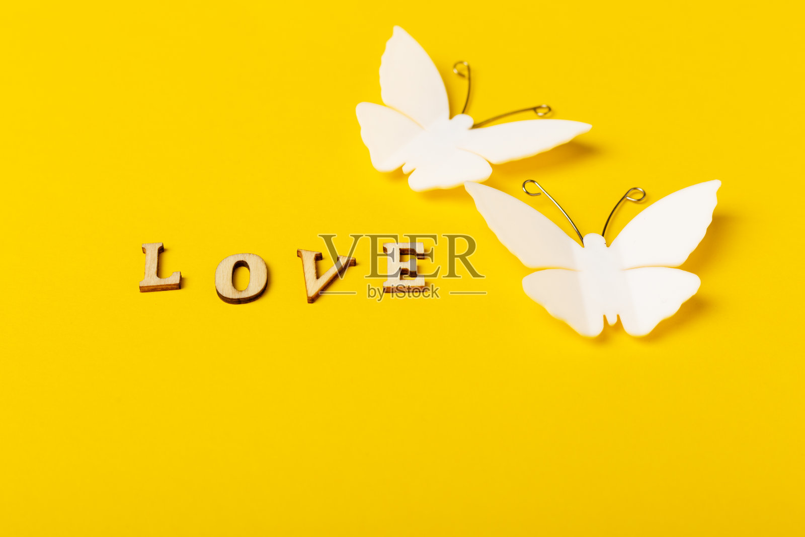 一对蝴蝶和文字爱在黄色的背景照片摄影图片