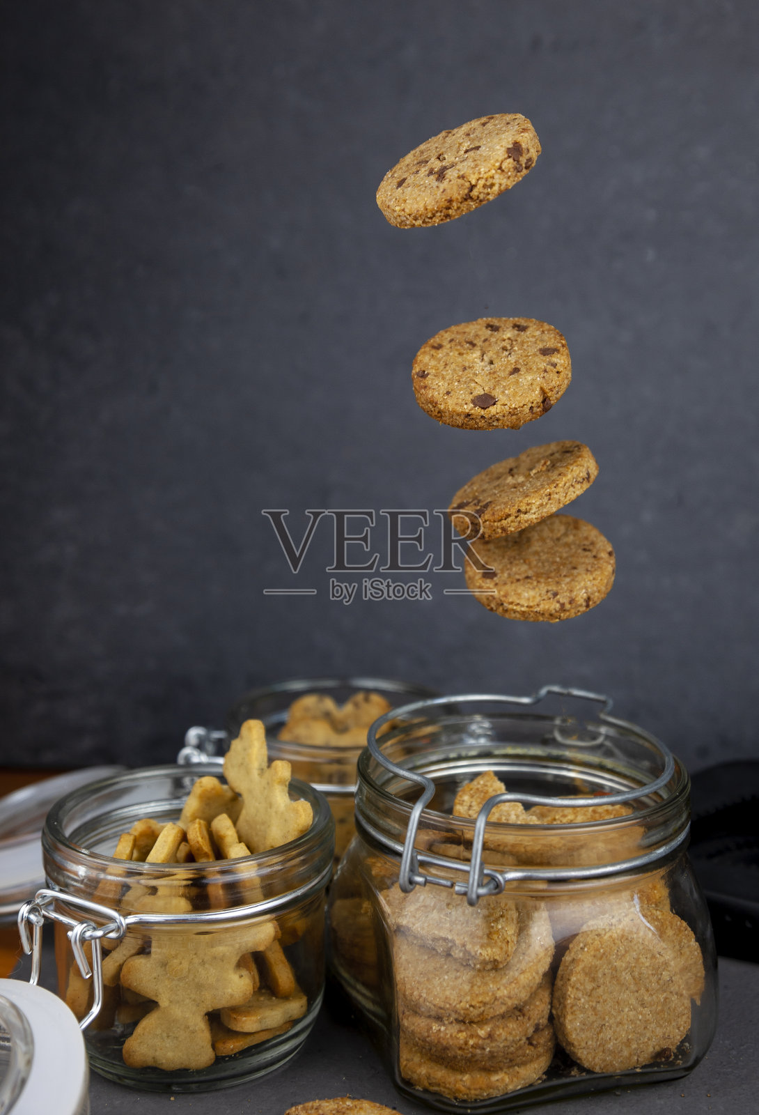 杏仁饼干和越橘饼干。圆的自制饼干飞在一个罐子里。悬浮的饼干。饼干、甜糕点、自制面粉制品照片摄影图片