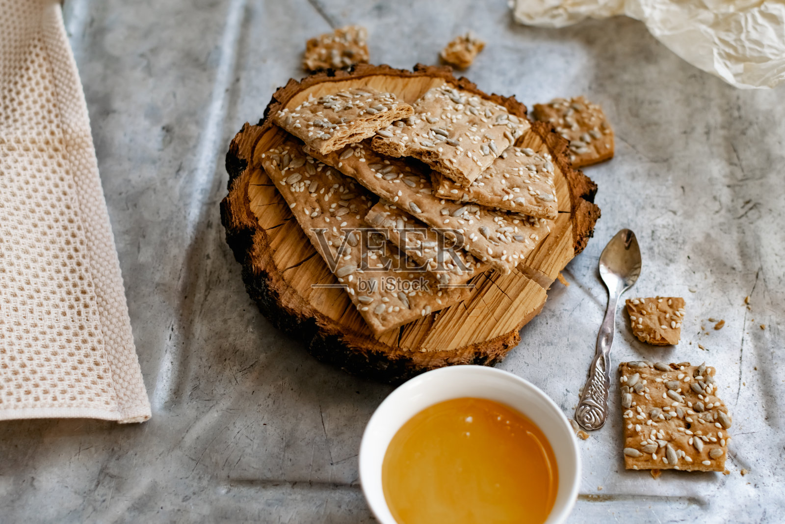 健康营养的面包，加上芝麻和葵花籽和松脆的薄麦芽。靠近天然的蜂蜜和木头照片摄影图片