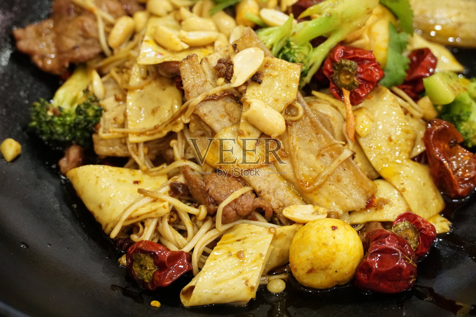 麻辣烫香果-中国的流行菜，炒什锦蔬菜，蘑菇和肉在热辣椒调味的黑色盘子-关闭照片摄影图片
