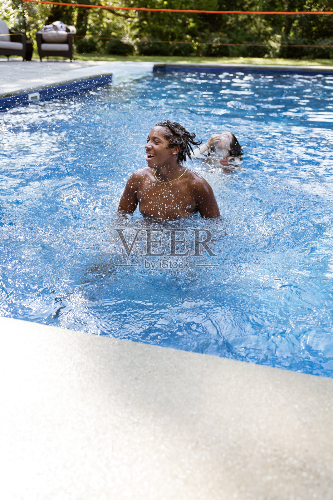 一个小男孩在游泳池里游泳照片摄影图片