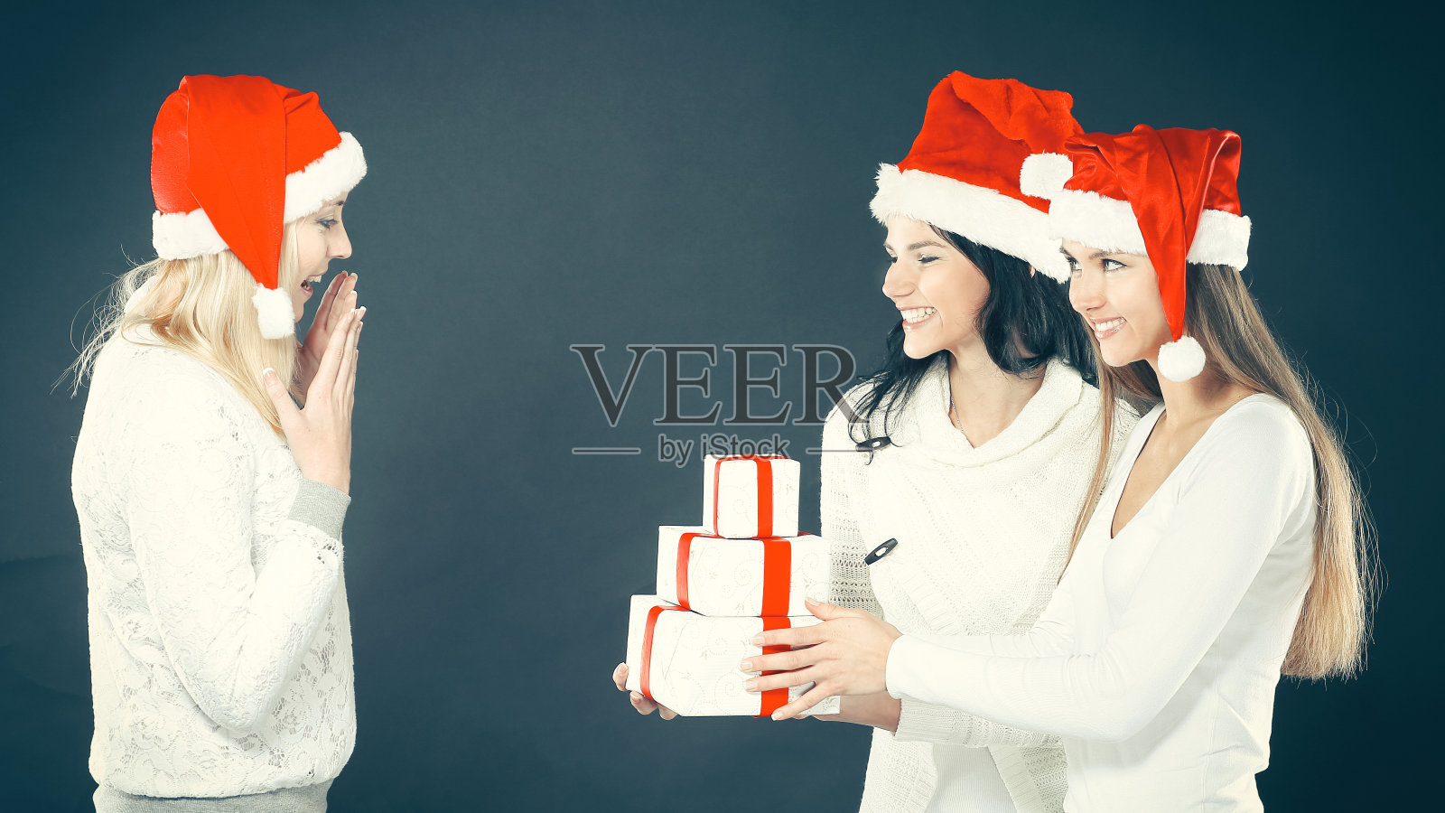 三个穿着圣诞老人服装的女人在圣诞购物照片摄影图片