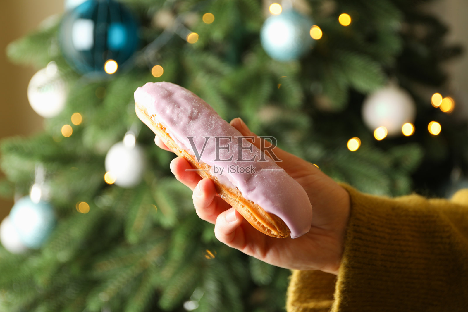 女性手握美味的松饼在圣诞树的背景照片摄影图片