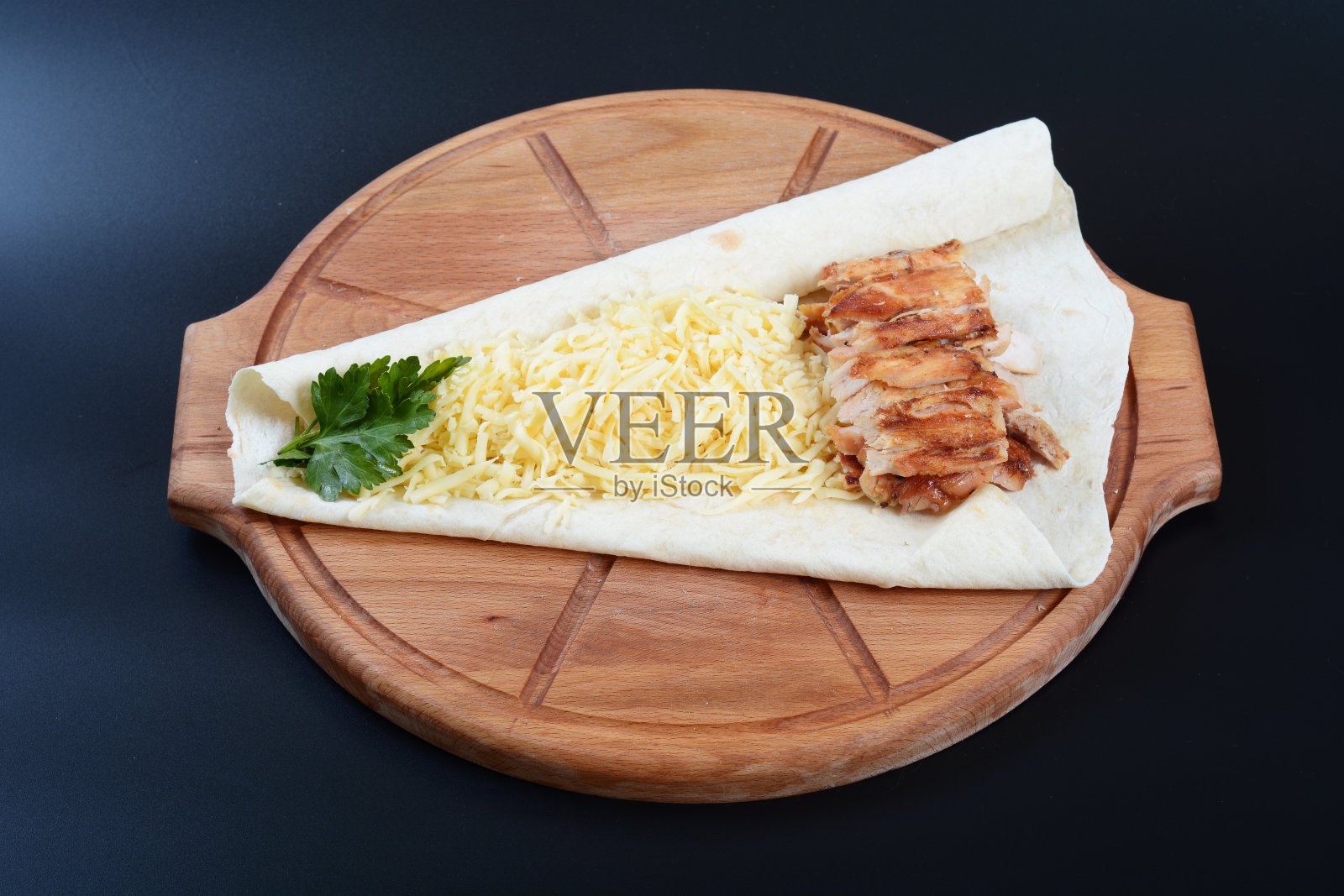 黑色的背景上放着番茄、黄瓜、肉和香草的玉米饼照片摄影图片