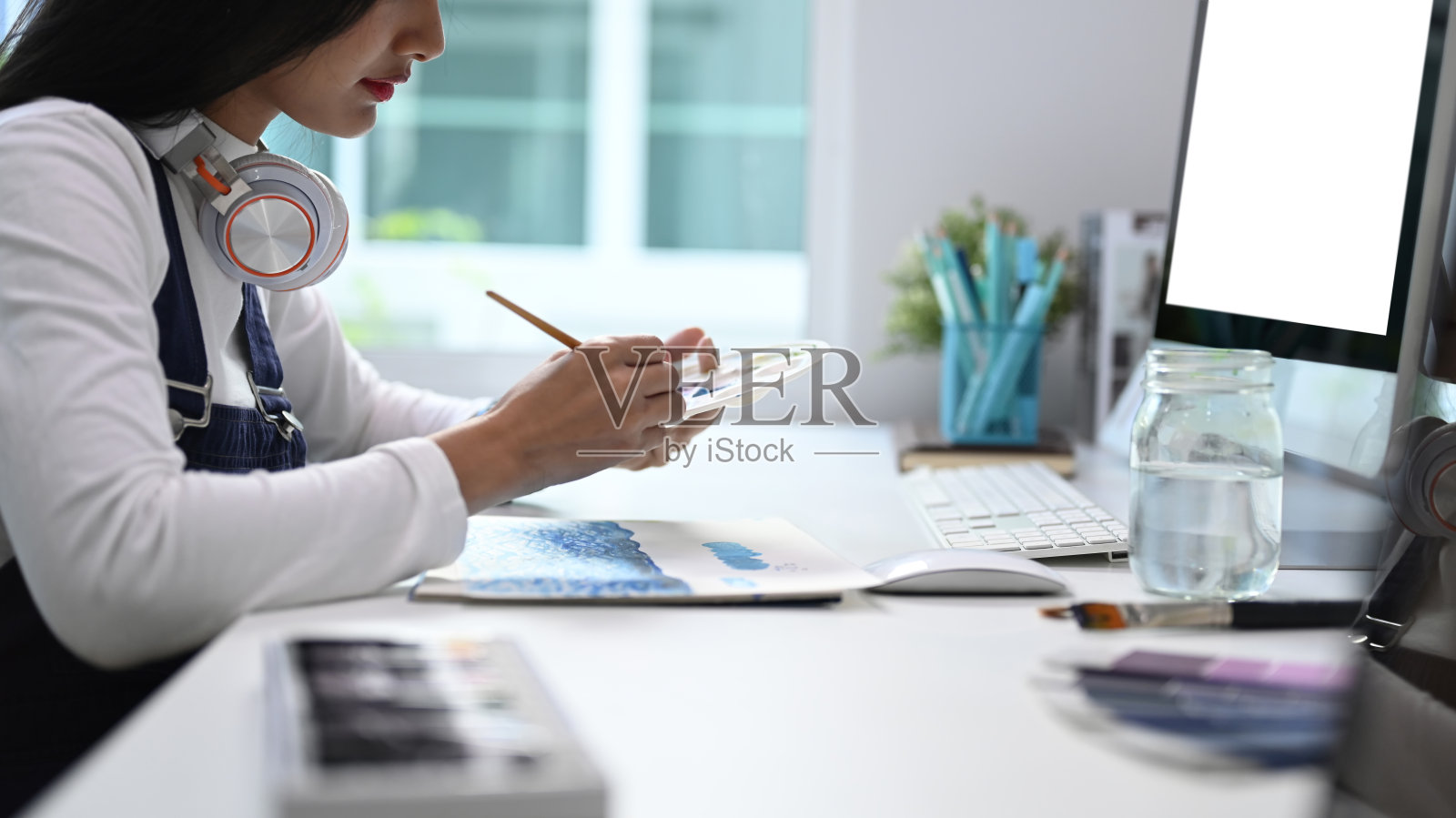 一位女性艺术家在她的工作室工作的艺术项目的侧视图。照片摄影图片