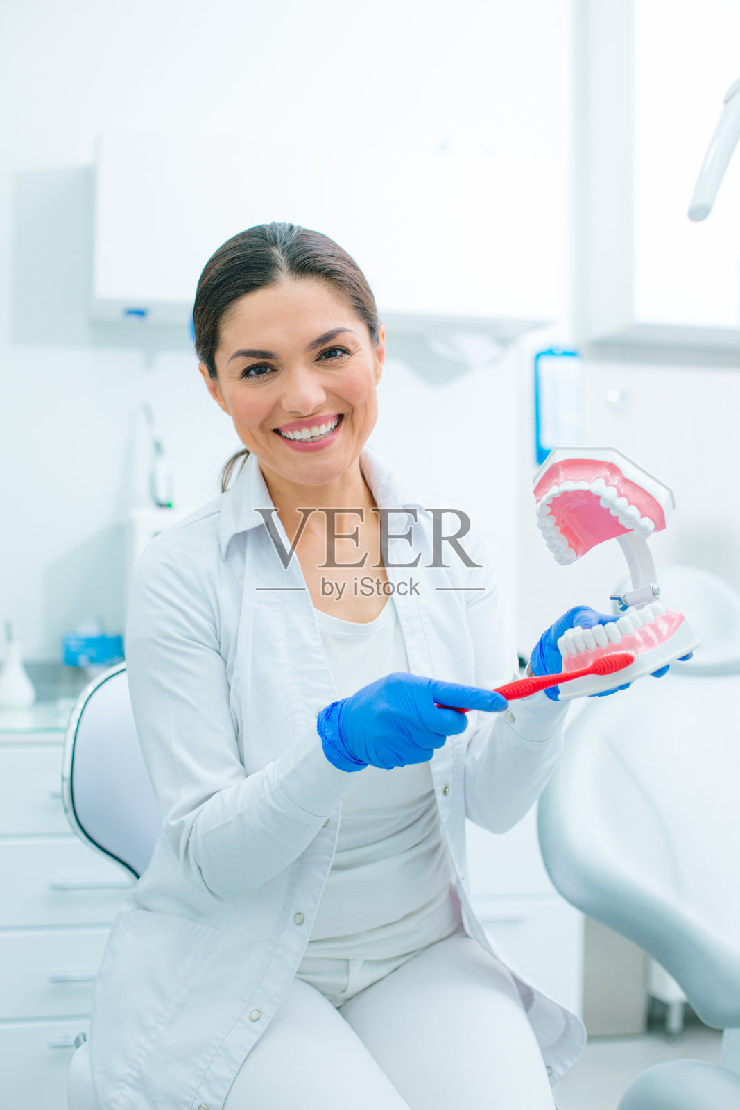 友善的牙医示范如何正确刷牙照片摄影图片