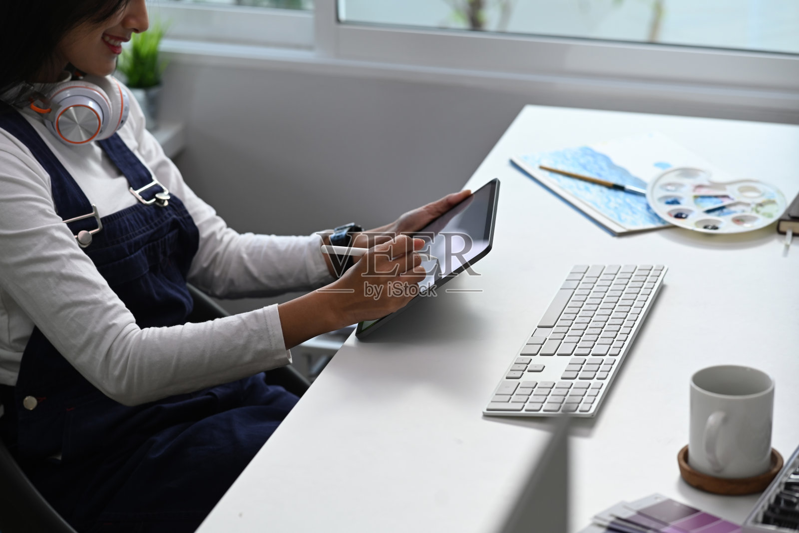 年轻时髦的平面设计师女性在现代工作空间使用数字平板电脑。照片摄影图片