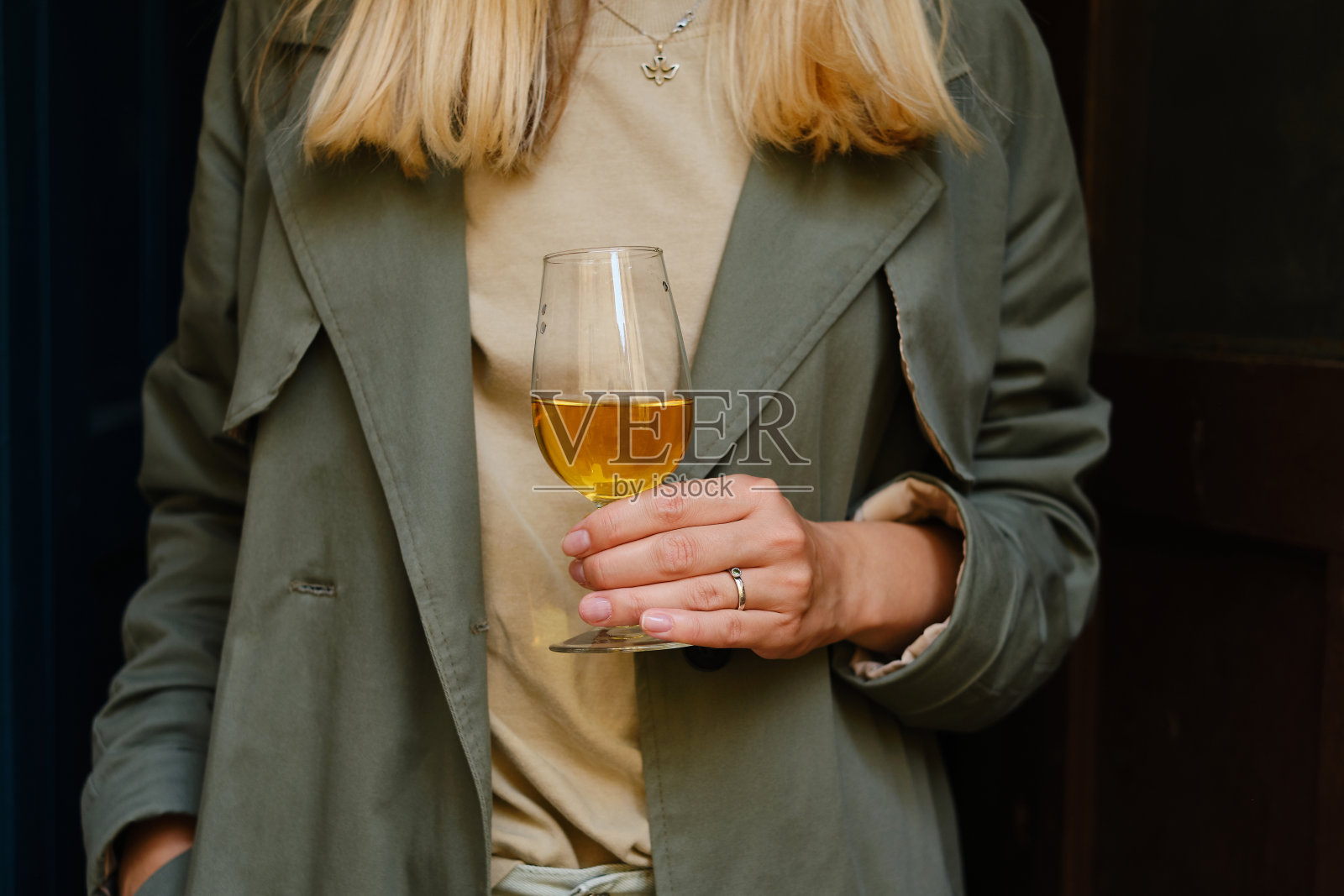 阳台上有个拿着酒杯的漂亮女孩。喝着白葡萄酒，享受这一刻。一个单独的庆祝节日。轻松的生活方式。快乐女人下班后休息。美丽的欧洲庭院照片摄影图片