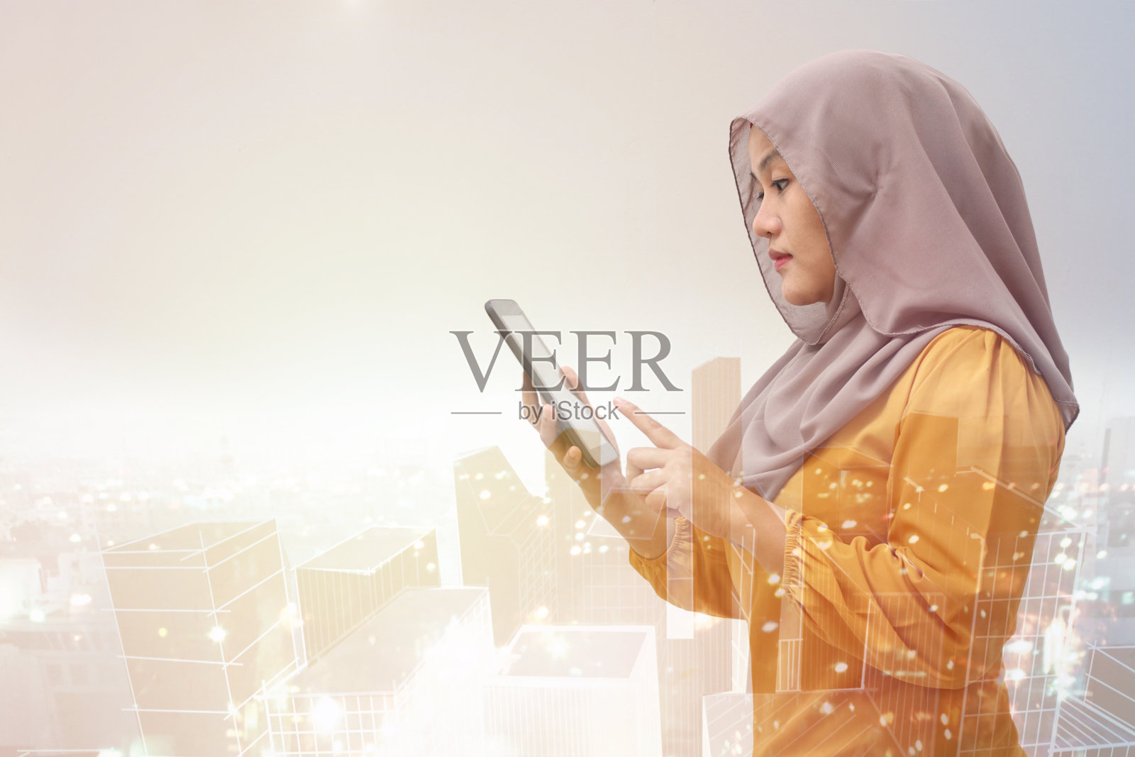 戴着头巾的穆斯林女商人使用智能手机或平板电脑照片摄影图片