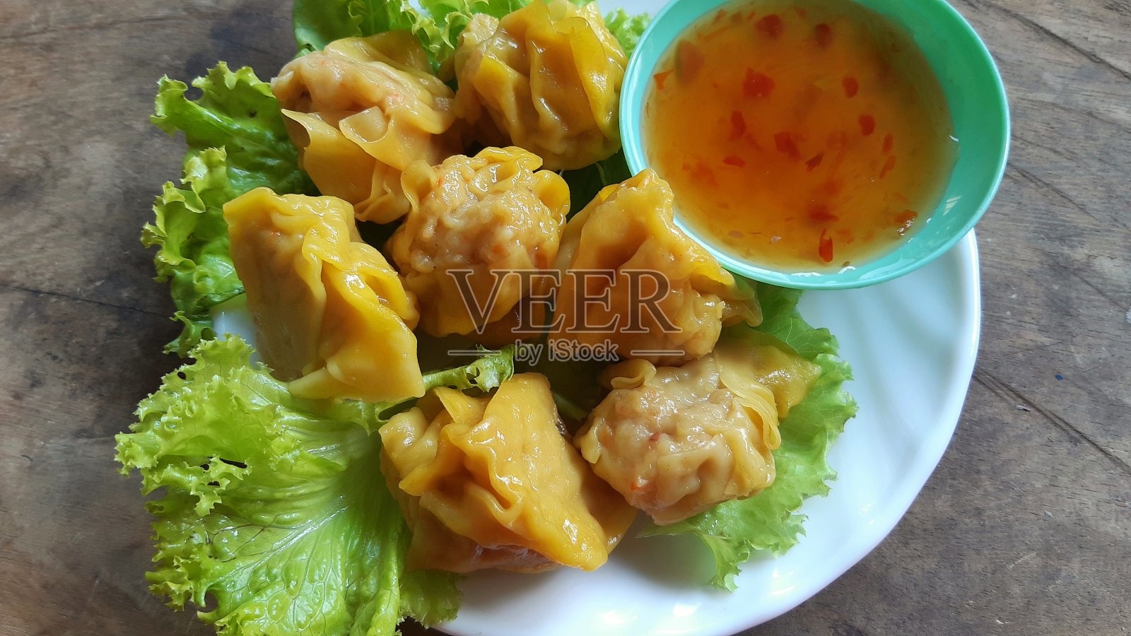 猪肉蒸饺孤立在木桌上。照片摄影图片