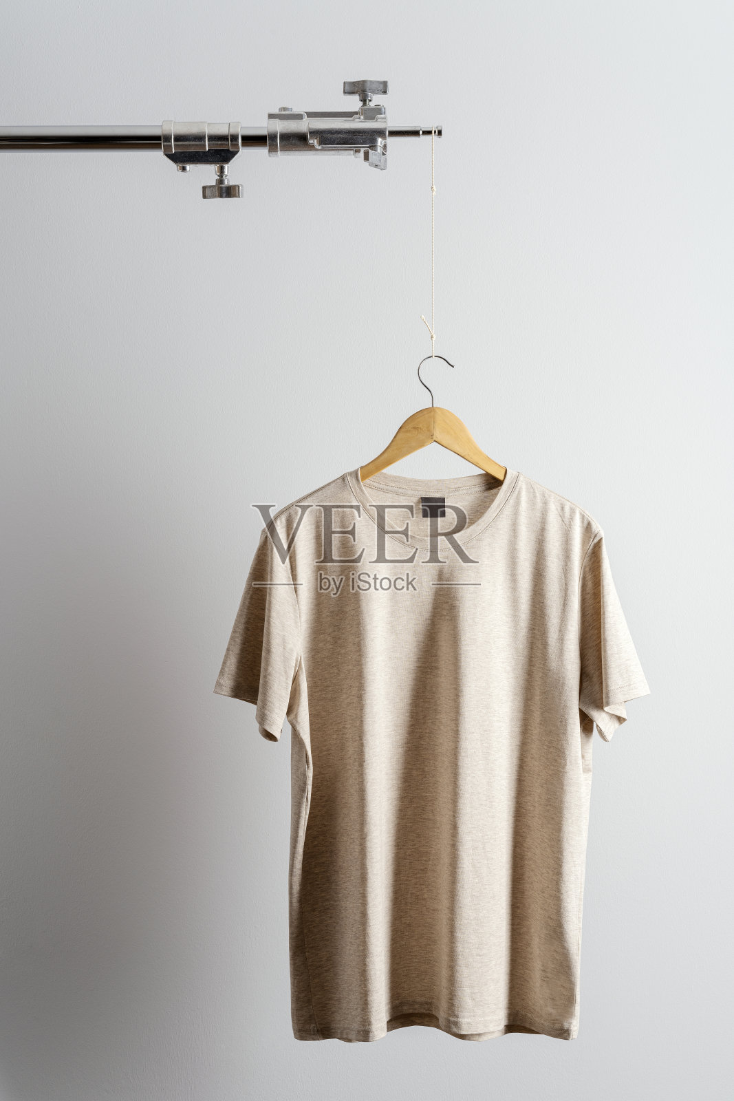 米色t恤放在照片三脚架上照片摄影图片
